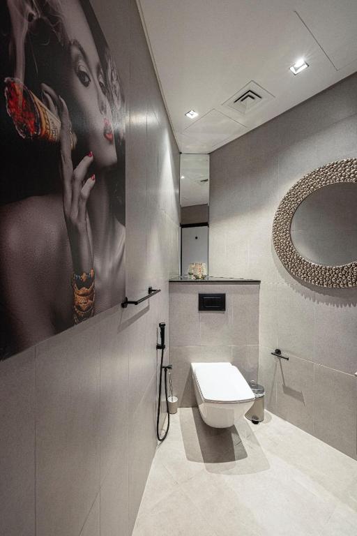 Bathroom with feature wall art, round mirror and walk-in shower
