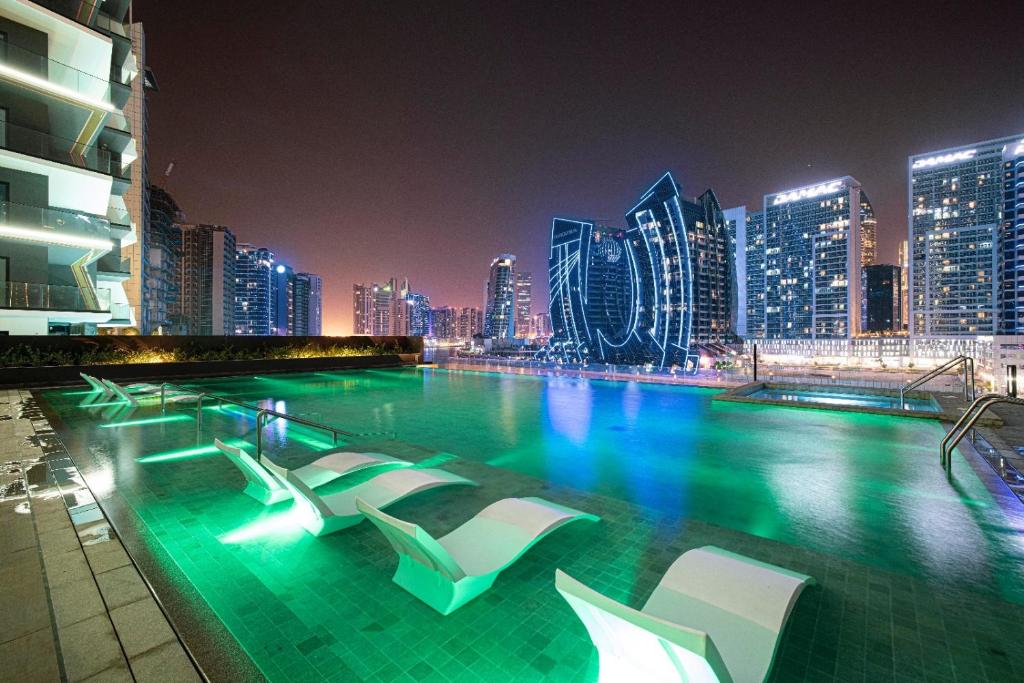 Rooftop pool with sculptural loungers under evening lighting