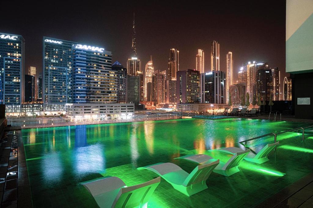 Rooftop infinity pool at night with the Dubai skyline lit up