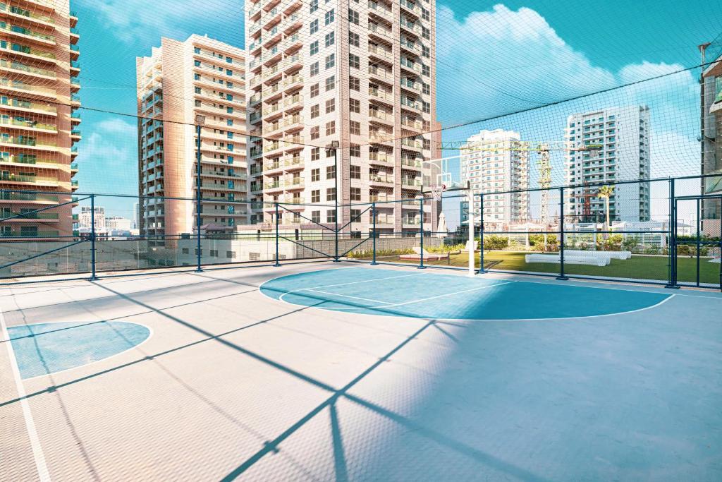 Rooftop basketball court framed by towers and skyline