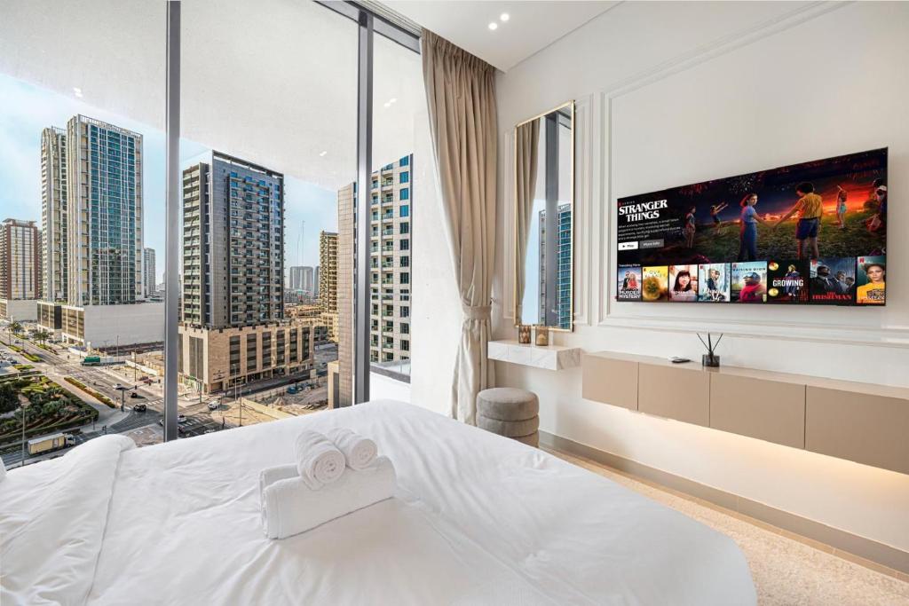 Second view of the bedroom with city-view windows, smart TV and mirror