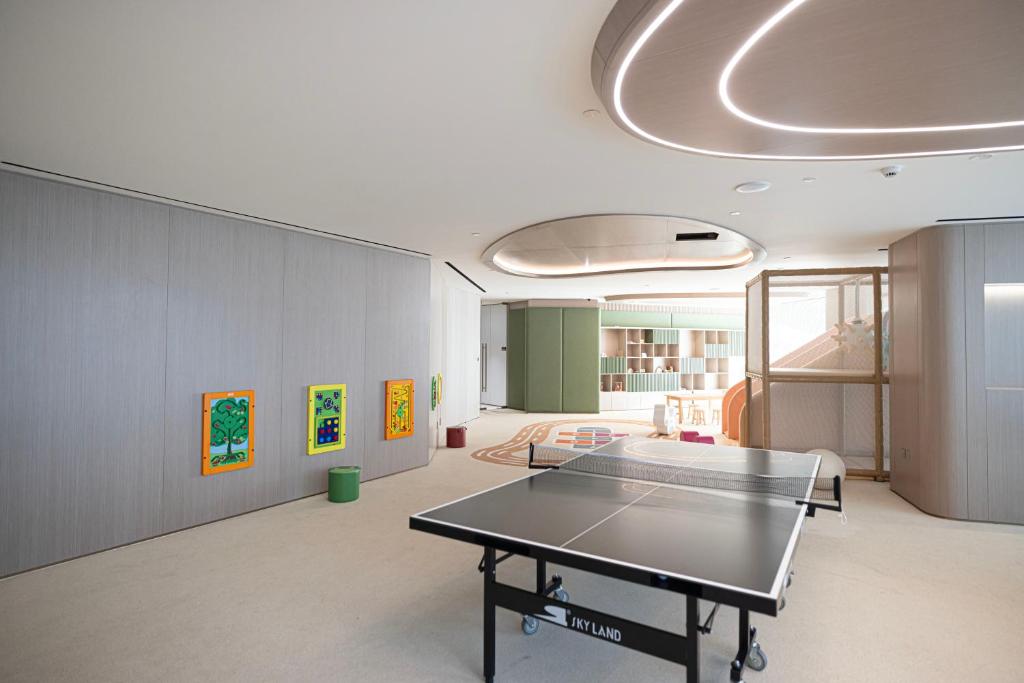 Table tennis table in a bright recreation room with colourful kids' wall games