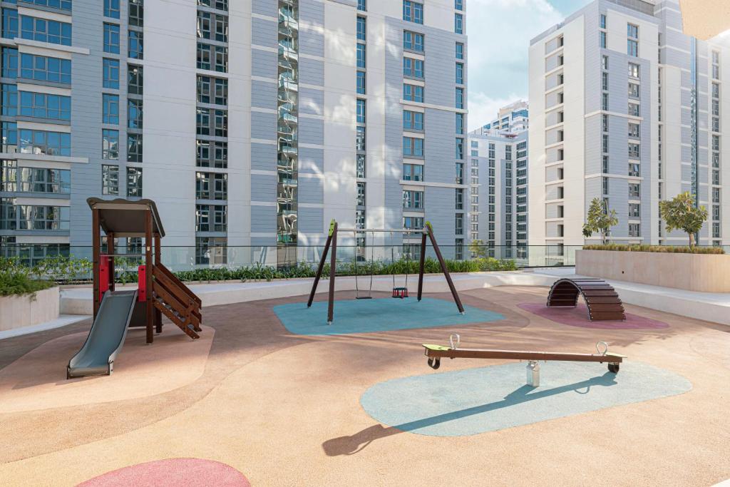 Outdoor children's playground with swings, slide and seesaw among the towers