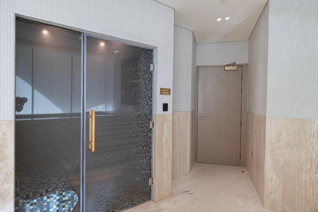 Steam room with a glass door and mosaic-tiled interior